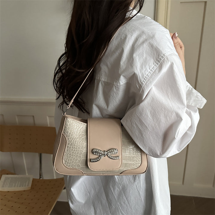 Elegante Handtasche mit Krokodilmuster und Schleifendetail