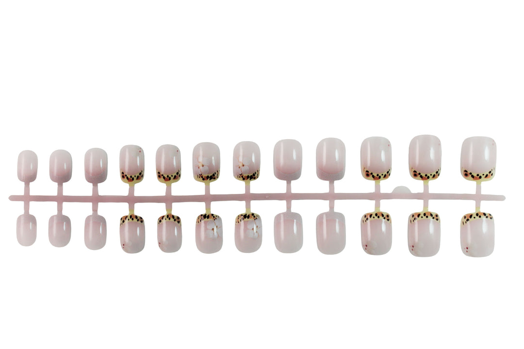 Kunstnagelset mit eleganter französischer Spitze und floralem Akzent Karnz