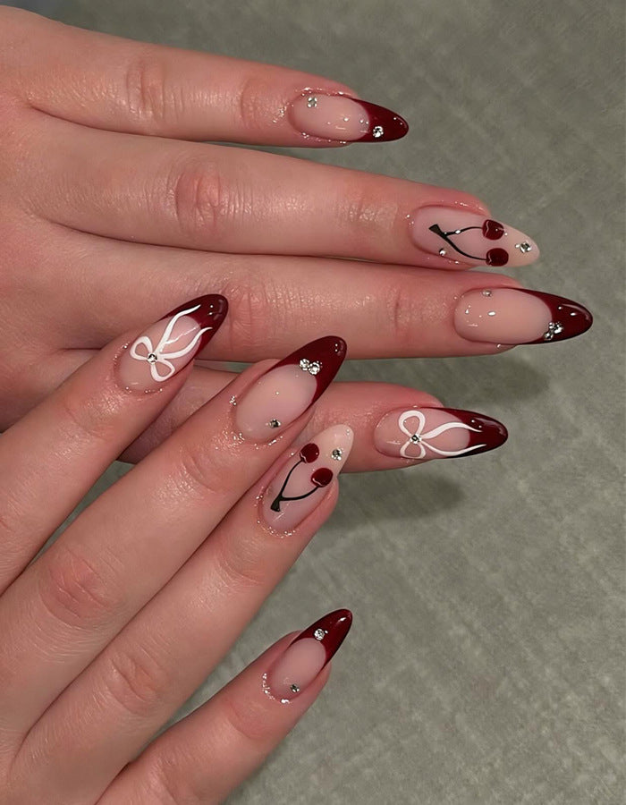 Künstlerisches Stiletto Press-On Nagelset mit Kirsch- und Schleifenmotiven Karnz