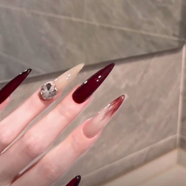 Elegante Stiletto Nagelverbesserungen mit Edelsteinakzenten Karnz