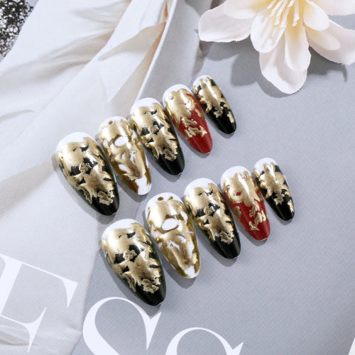 Elegante Kunstnägel mit Gold- und Schwarzmuster Karnz