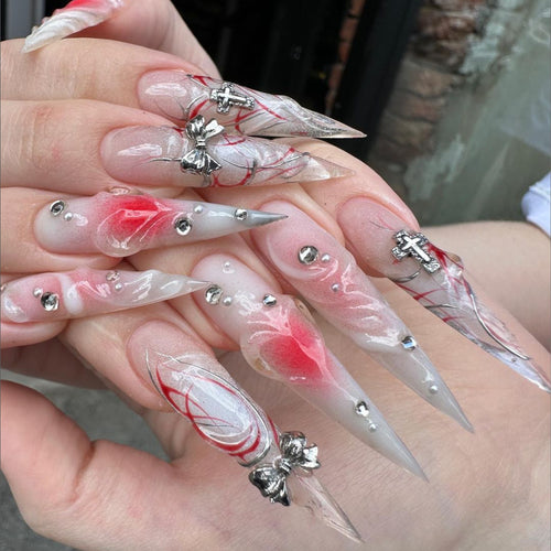 Kunstvolle Stiletto-Nägel mit eleganter floralem Akzent und Glitzerverzierungen Karnz
