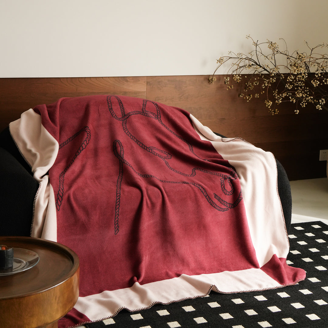 Wohndecke mit gesticktem Kordelmotiv und Ziernaht