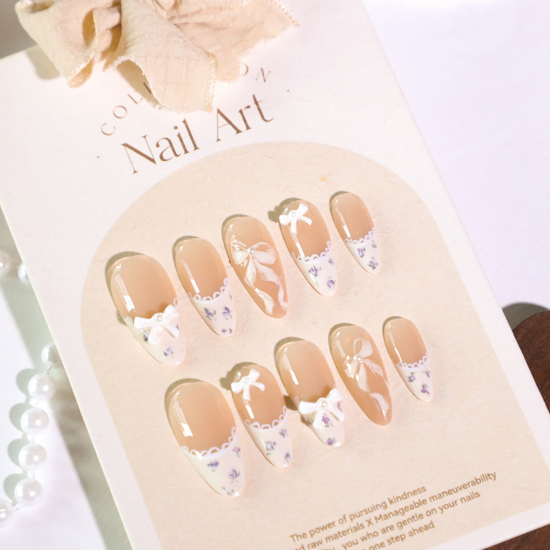 Kunstvolle Nagelkunst mit eleganten Schleifen und Strass-Details Karnz