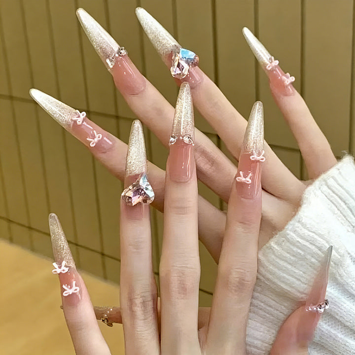 Kunstnagelset mit funkelnden Spitzen und zarten Schleifenverzierungen Karnz