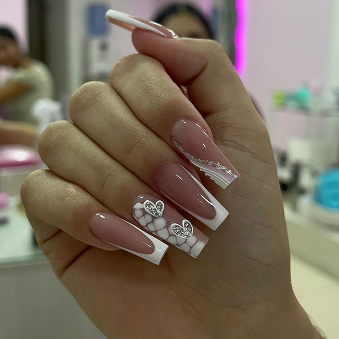Kunstvolle Nagelverlängerungen mit Herzdesign und Glitzerakzenten Karnz