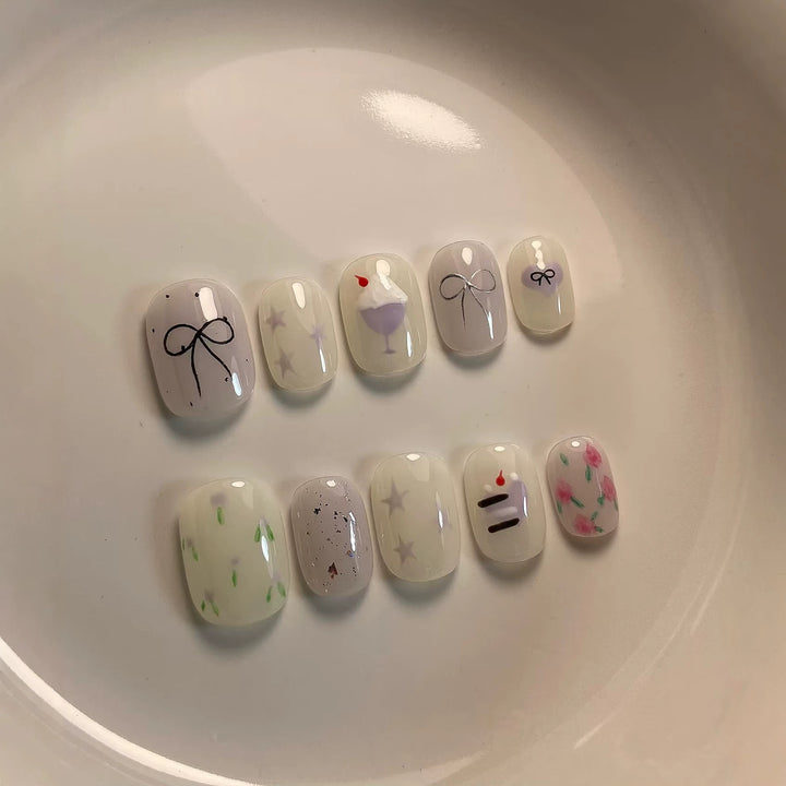 Künstlerisches Press-On Nagelkunstkset mit niedlichen Kuchen- und Banddesigns