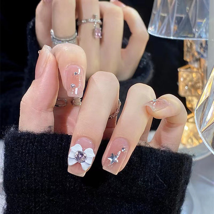 Kunstvolle Nagelspitzen mit floralen und glitzernden Akzenten Karnz