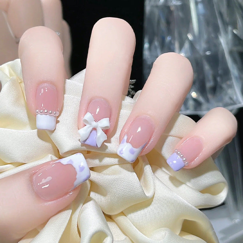 Kunstnagelset mit eleganten Wellenmustern und zarten Perlenakzenten Karnz