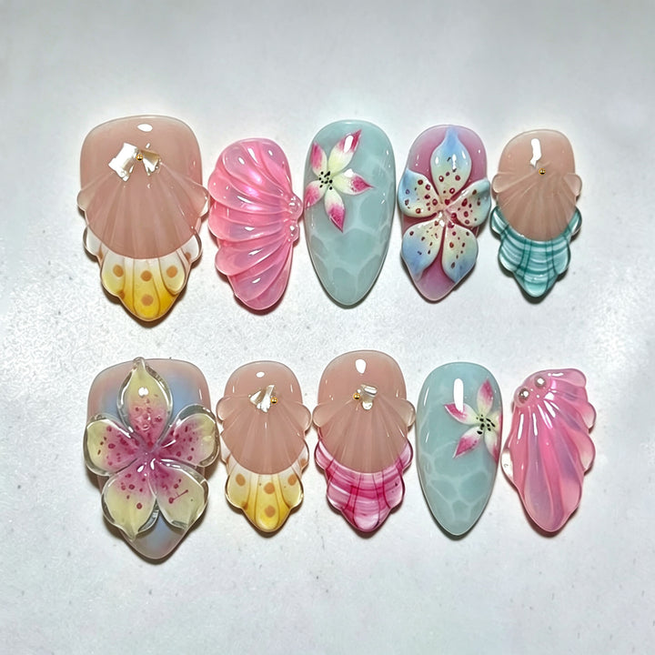 Künstlerisches Press-On-Nagelset mit floralen und Muschel-Designs