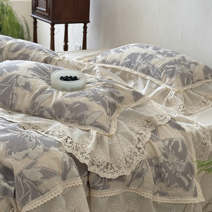 Leicht gesteppte Baumwoll-Bettwäschegarnitur im Landhausstil mit Spitzenvolant und großem Blumenmotiv