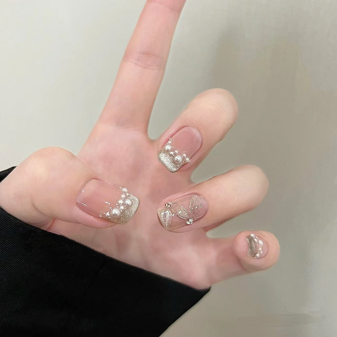 Elegante Kunstnägel mit Perlenschmuck und Glitzereffekten Karnz