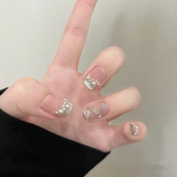 Elegante Kunstnägel mit Perlenschmuck und Glitzereffekten Karnz