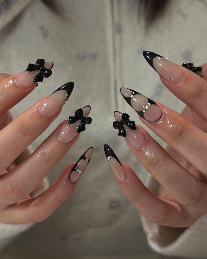 Kunstnagelset mit schimmernden Akzenten und eleganten Schleifen Karnz