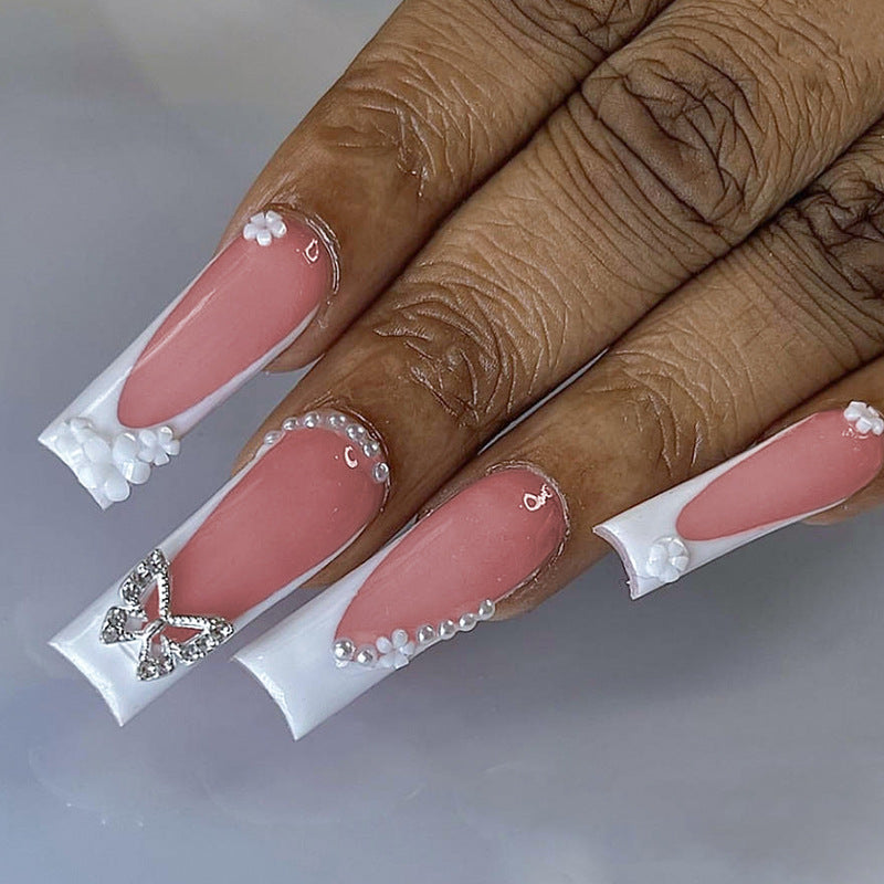 Kunstnagelset mit eleganten floralen Verzierungen und Glitzerakzenten Karnz