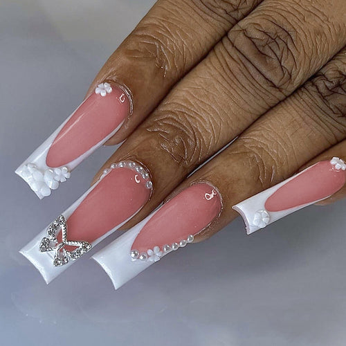 Kunstnagelset mit eleganten floralen Verzierungen und Glitzerakzenten Karnz