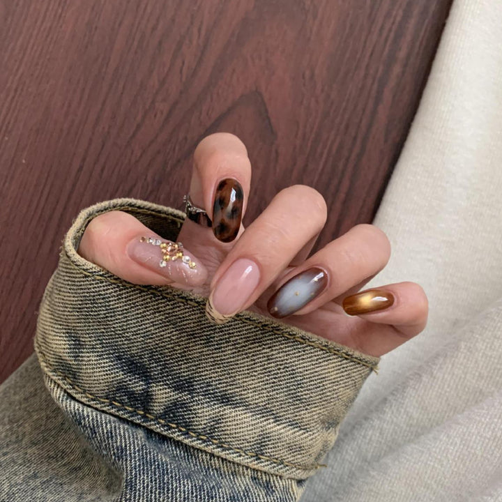 Kunstnagelset mit Eleganten Mustern und Glitzerakzenten Karnz