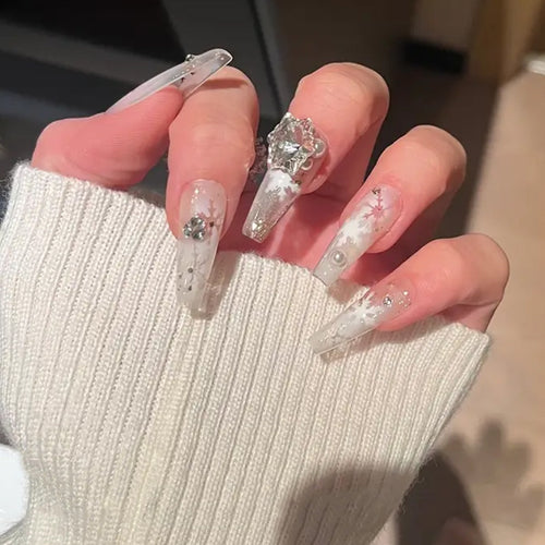 Kunstnagelset mit frostigem Schneeflocken-Design und funkelnden 3D-Applikationen Karnz