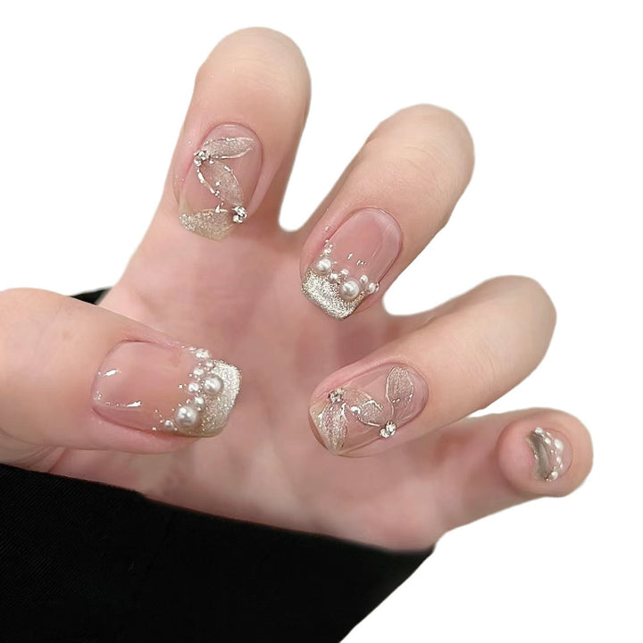 Elegante Kunstnägel mit Perlenschmuck und Glitzereffekten Karnz