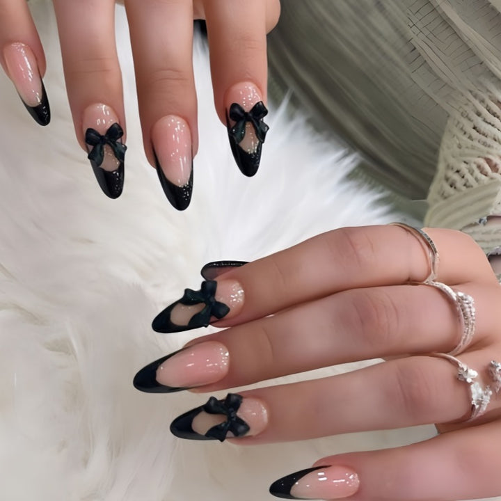 Künstlerisches Stiletto Press-On Nageldesign mit Schleifenakzenten Karnz