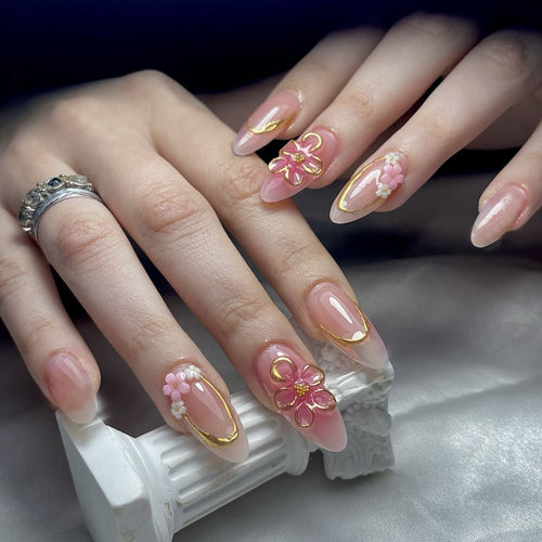 Kunstnagelset mit eleganten Blüten- und Goldverzierungen Karnz