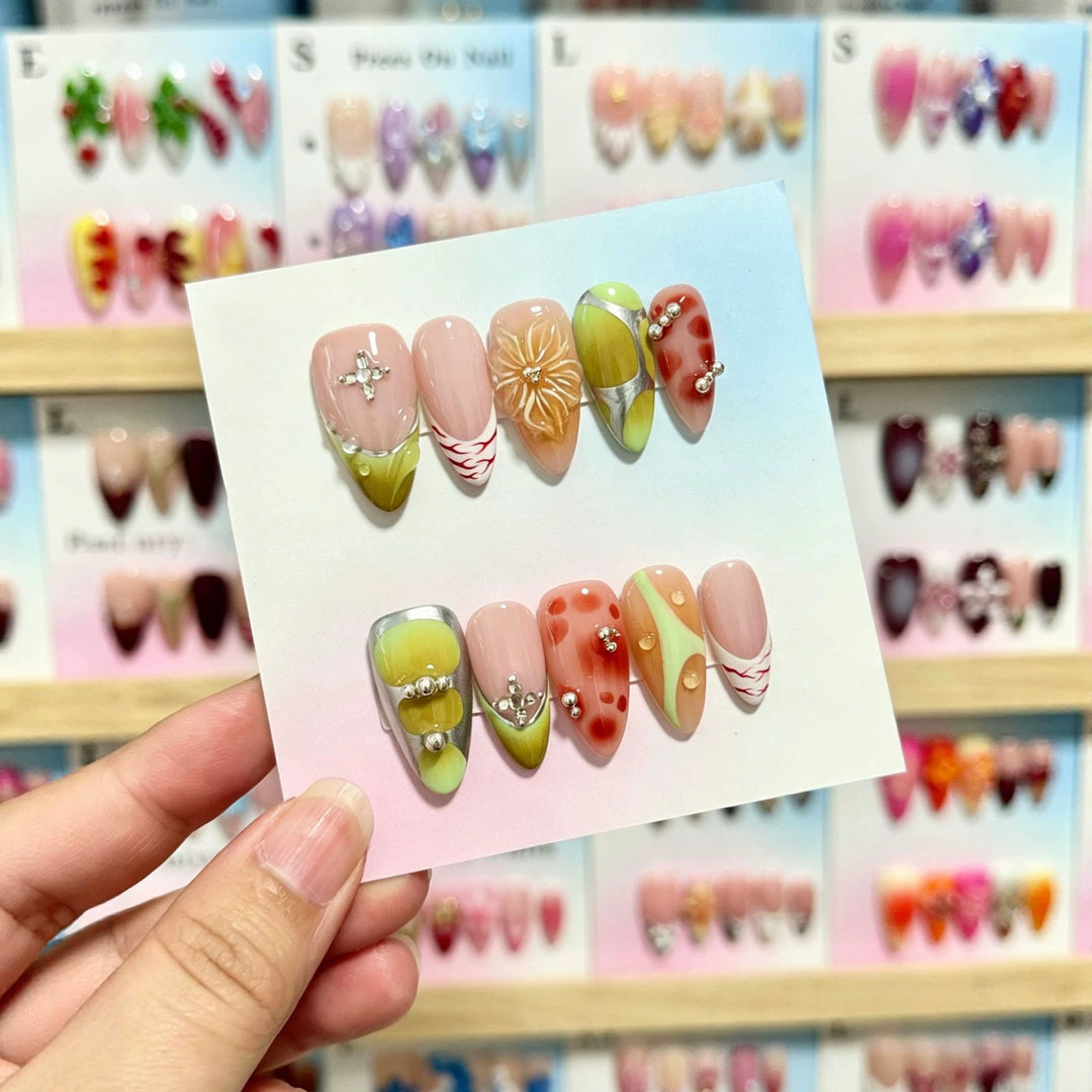 Künstlerisches Press-On-Nagelset mit dekorativen floralen und Juwelenelementen