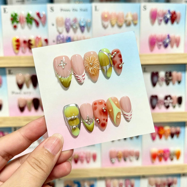 Künstlerisches Press-On-Nagelset mit dekorativen floralen und Juwelenelementen