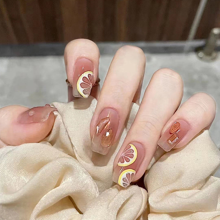 Kunstnagelset mit fröhlichen Zitrusmotiven und eleganten Designs Karnz