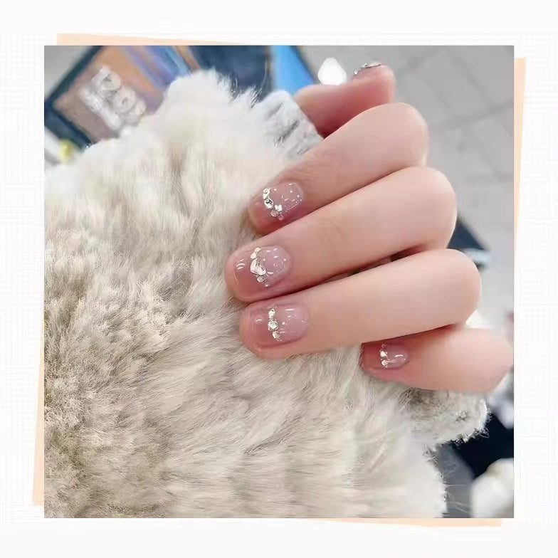 Kunstvolle Nagelkunst mit Schmetterlings- und Perlendetails Karnz