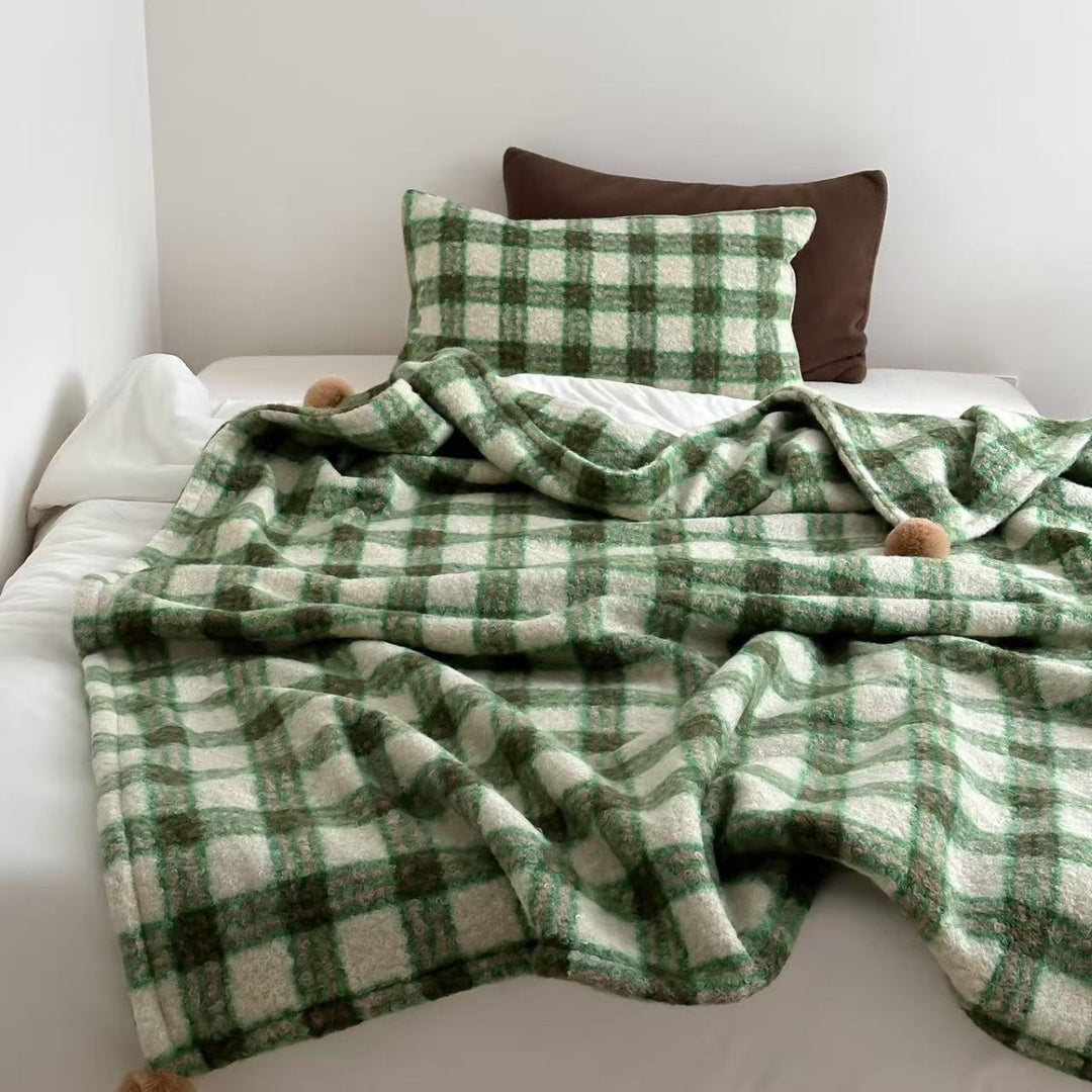 Kuscheldecke mit kariertem Muster und Bommelverzierung Karnz