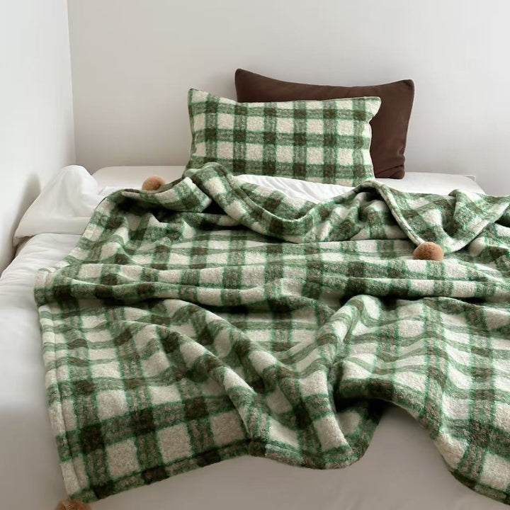 Kuscheldecke mit kariertem Muster und Bommelverzierung Karnz