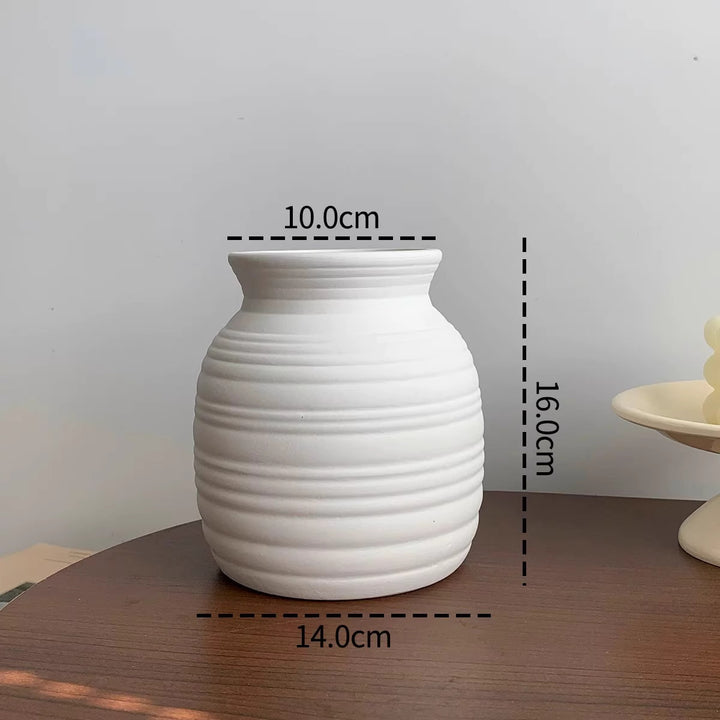 Minimalistische matte Keramikvase mit naturähnlichem Kunstgänseblümchenstrauß