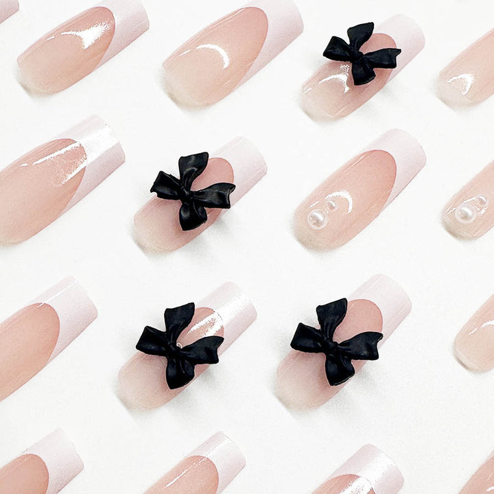 Kunstnagelset mit stilvollen Schwarz- und Perl-Details Karnz