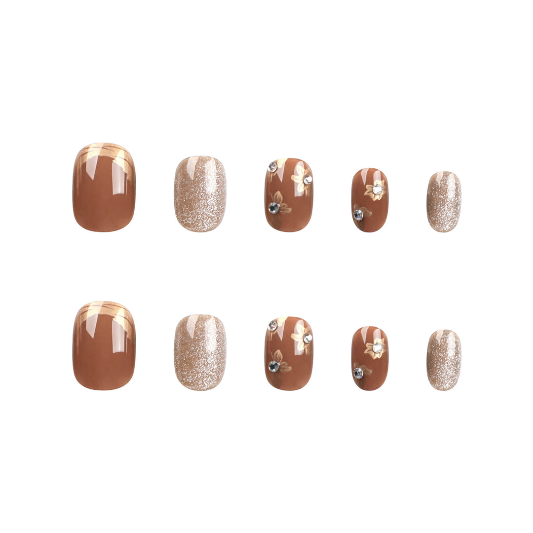 Elegante Nageldekoration mit Glitzer und floralen Akzenten Karnz