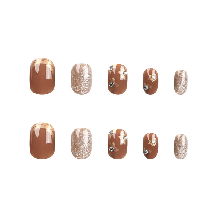 Elegante Nageldekoration mit Glitzer und floralen Akzenten Karnz