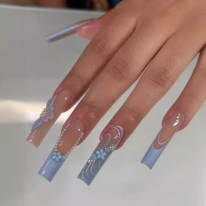 Kunstnagelset mit zarten floralen Akzenten und eleganten Verzierungen Karnz