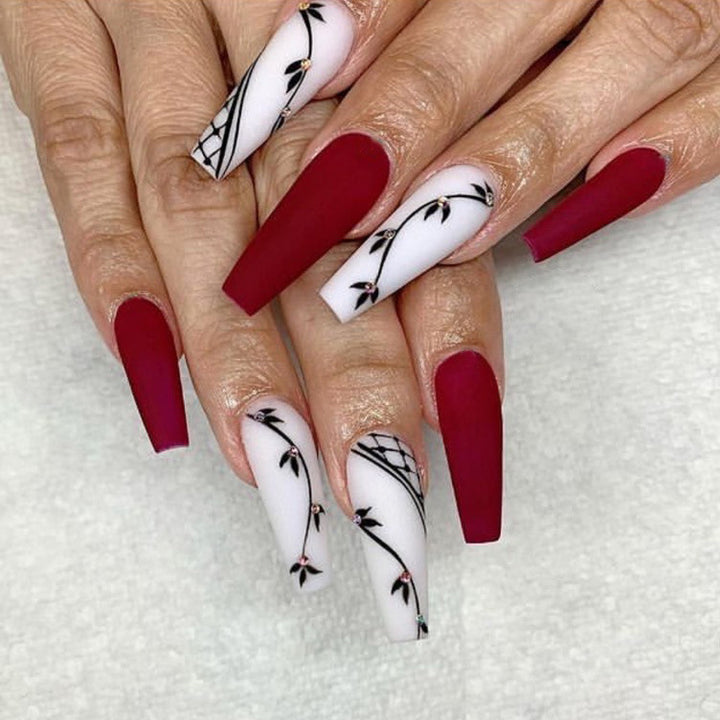 Künstlerisches lange Press-On Nagelset mit floralen Akzenten Karnz