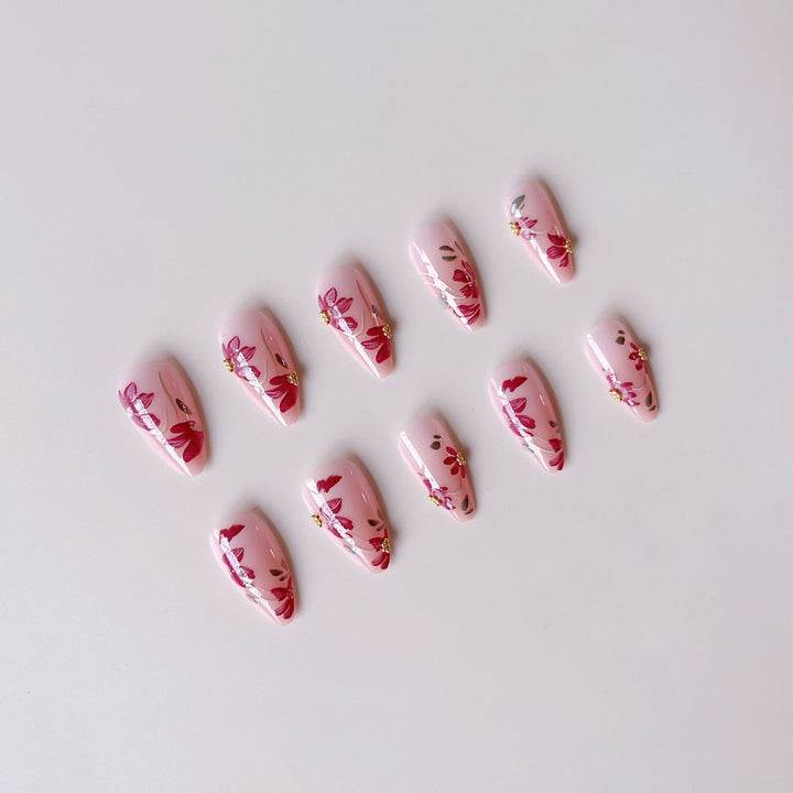 Kunstnagelset mit floralen Mustern und goldenen Akzenten Karnz