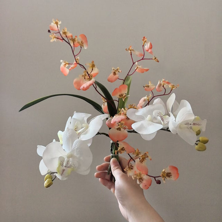 Lebensechte Orchideen Blumenarrangement