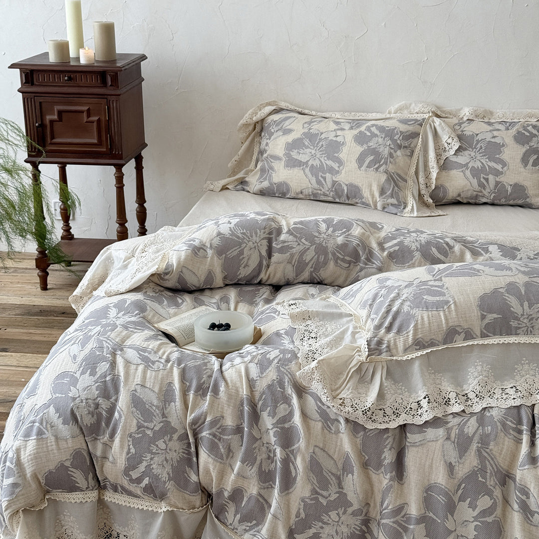Leicht gesteppte Baumwoll-Bettwäschegarnitur im Landhausstil mit Spitzenvolant und großem Blumenmotiv