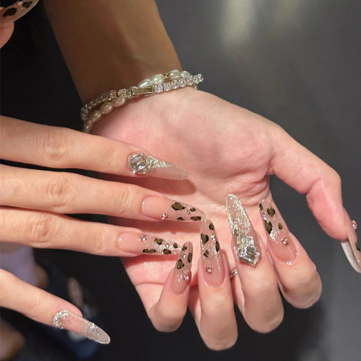 Glamouröses Kunstnagelset mit lustigem Leoparden-Muster und glitzernden Akzenten Karnz