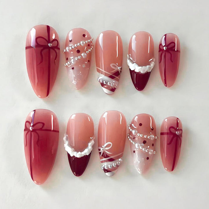Kunstnagelset mit glamourösen Schleifen und eleganten Perlenverzierungen Karnz