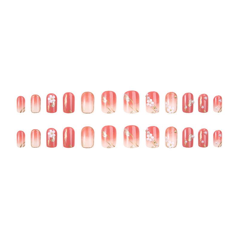 Kunstnagelset mit eleganten Blumendekoren und glamourösen Perlenakzenten Karnz