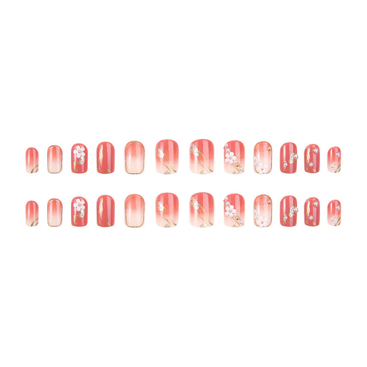 Kunstnagelset mit eleganten Blumendekoren und glamourösen Perlenakzenten Karnz