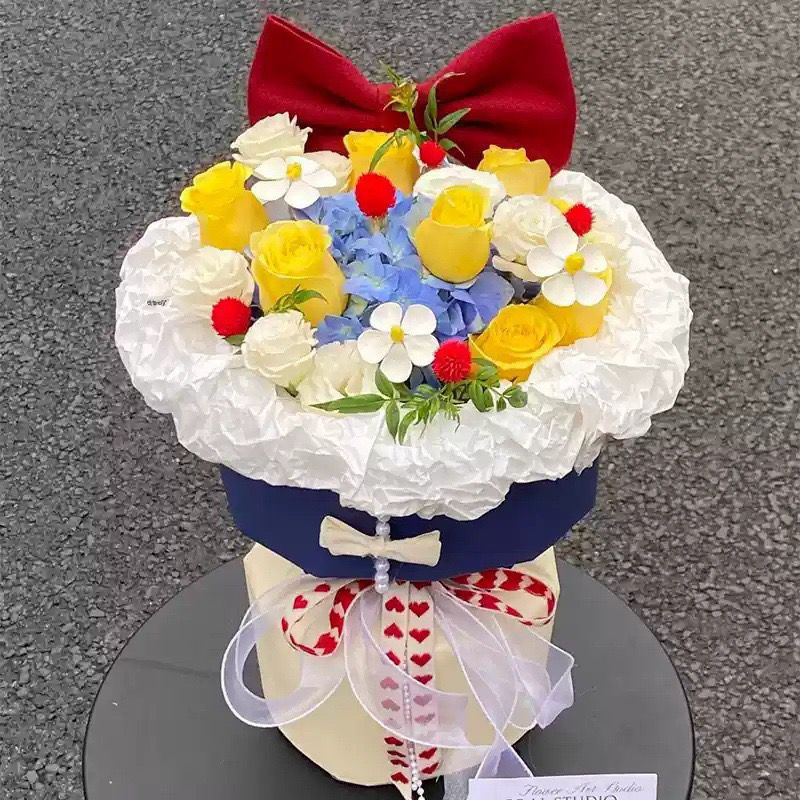 Künstliches Blumenarrangement mit Schleifenakzent
