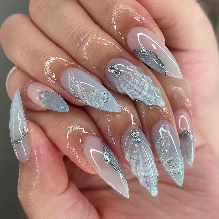 Kunstvolle Stiletto-Nägel mit eleganten Glitzer- und floralem Design Karnz