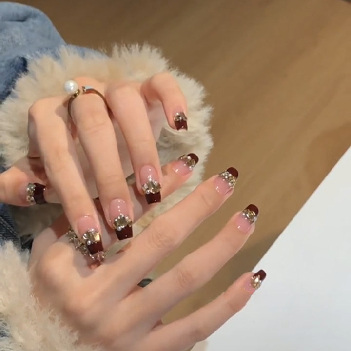 Kunstvolle Nagelverlängerungen mit Glitzer- und Schmuckverzierungen Karnz