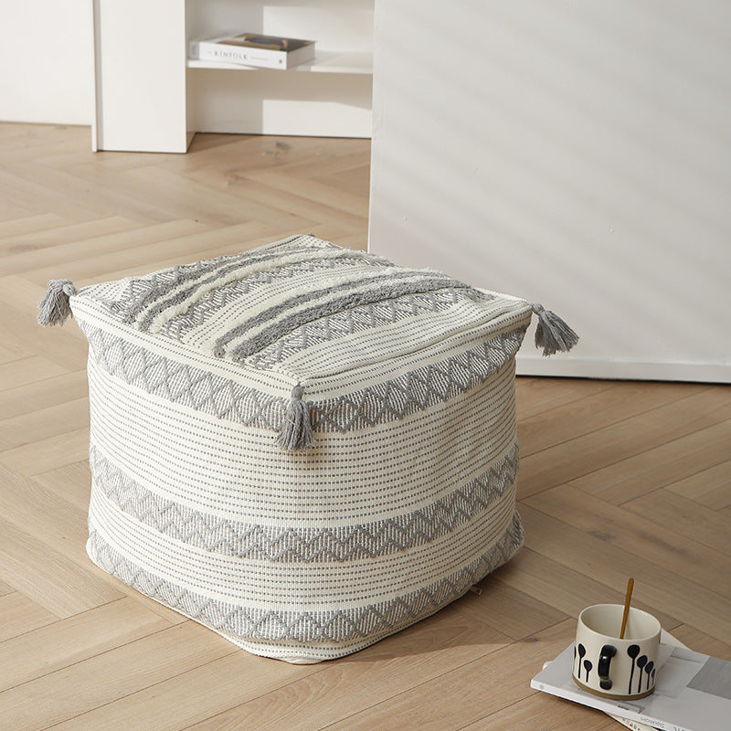 Geflochtener quadratischer Bodensitzpouf mit Quasten und gewebtem Ethno‑Muster
