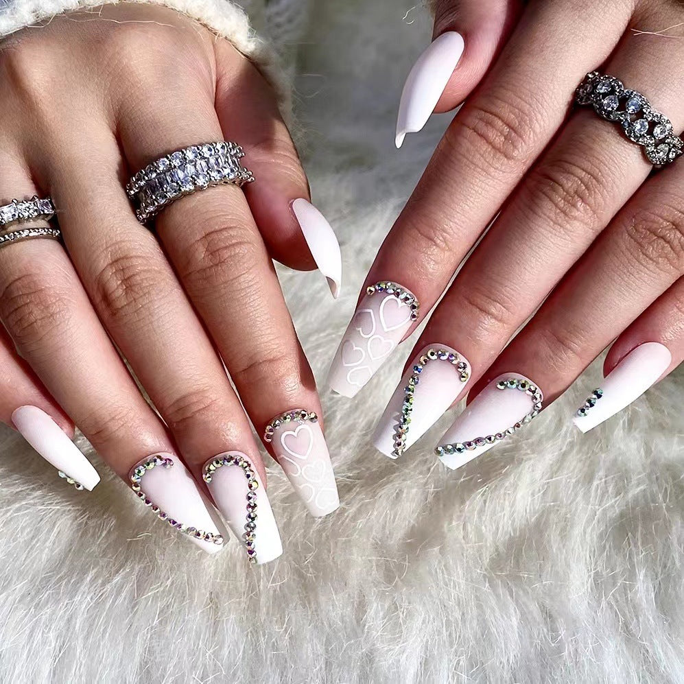 Kunstvolle Nagelverlängerungen mit Herzen-Design und Glitzerakzenten Karnz