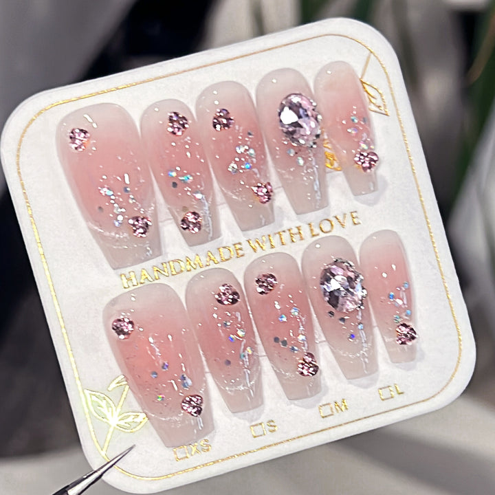 Künstliche Nagelverlängerungen mit kunstvollen Glitzerakzenten Karnz